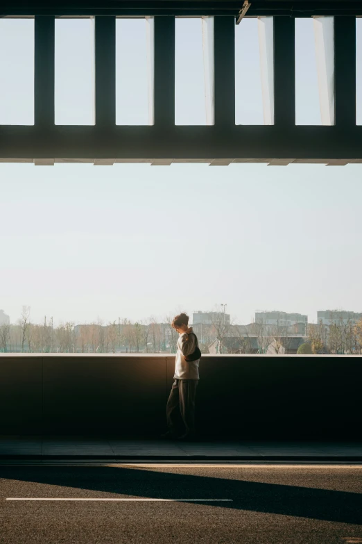 man walking near large metal beam in city