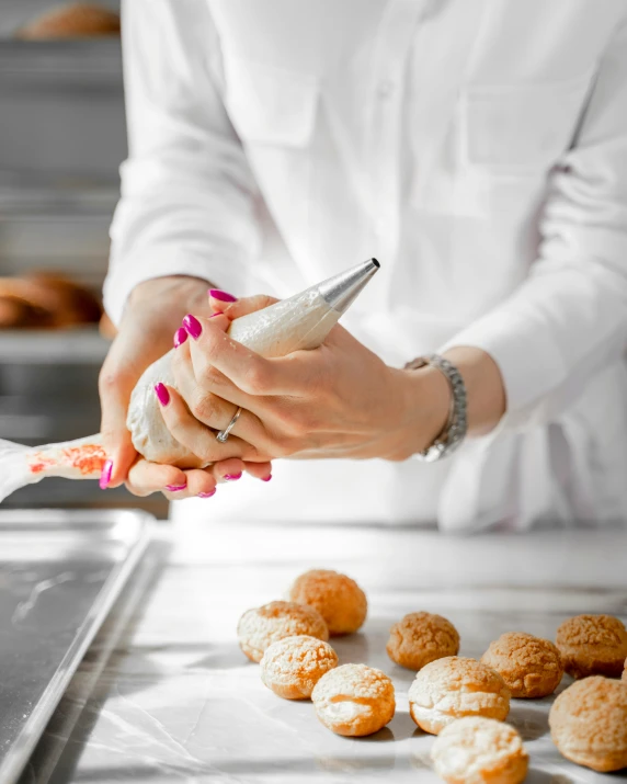 a woman is preparing a tray with pastries