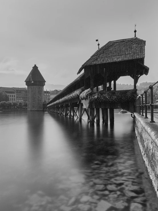 a wooden bridge is crossing the water in the dark