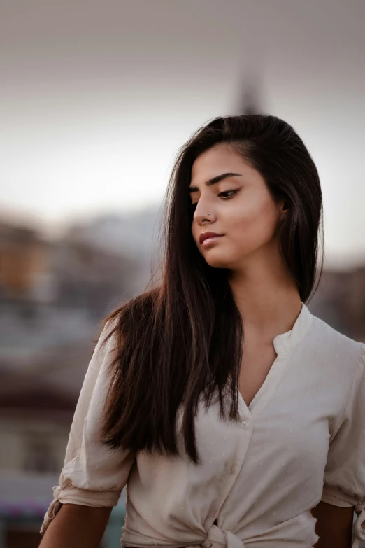 a woman posing with the sun setting in the background