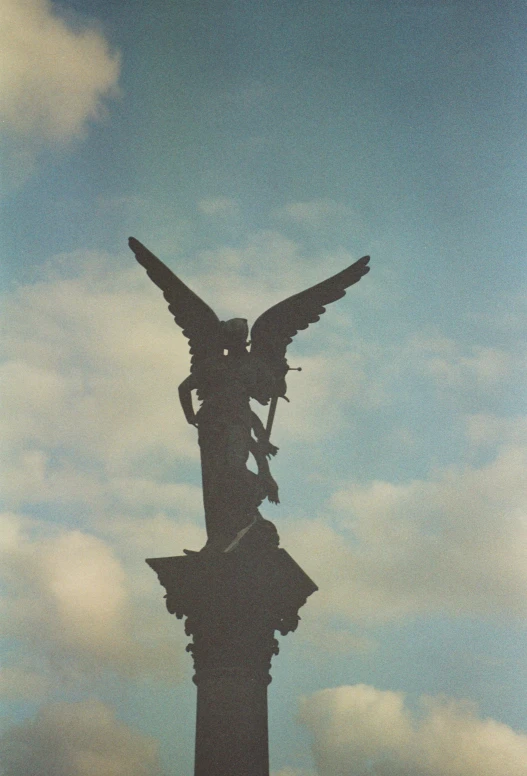 there is a angel standing on top of a sculpture