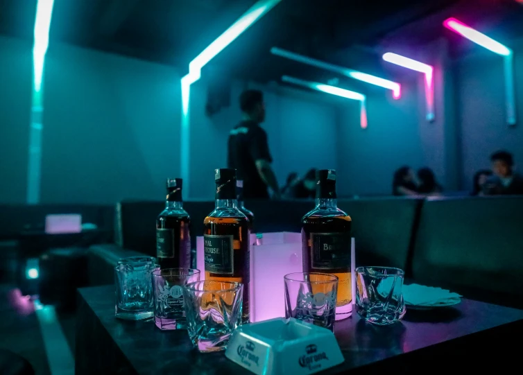 three bottles and glasses of alcohol on a table