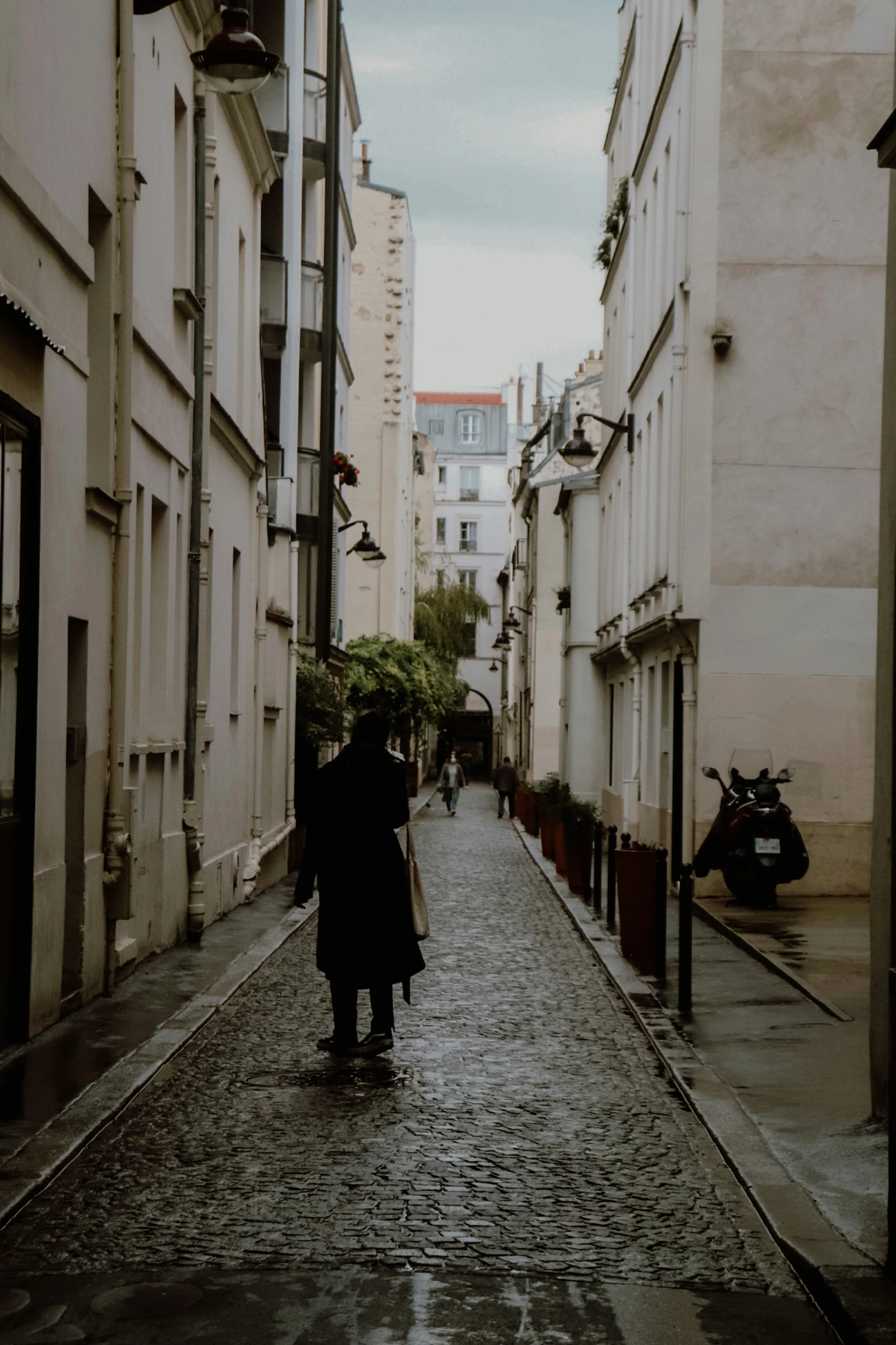 a man and woman walking down an alley