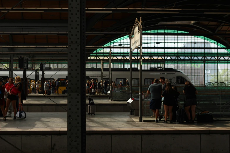 people at a train station waiting for a train