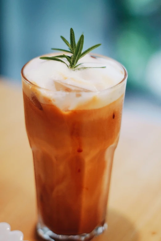 a glass filled with soing topped with a leaf