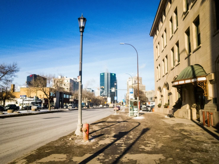 a city street with buildings on both sides and streetlights at the end