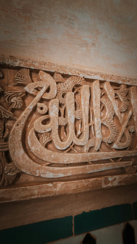 a carved capital with arabic writing, including two lions