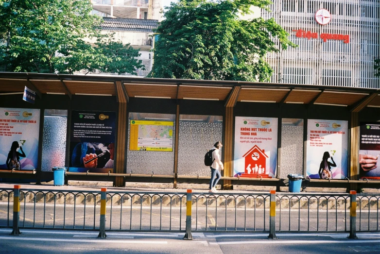 people walking past large advertising billboards on a city sidewalk
