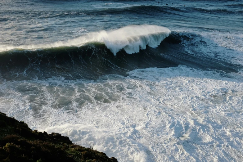 a very large wave in the ocean near the rocks