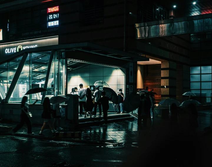 people outside a store at night on a rainy night