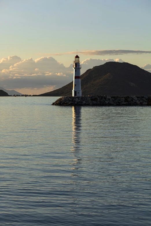 an lighthouse stands on top of a mountain