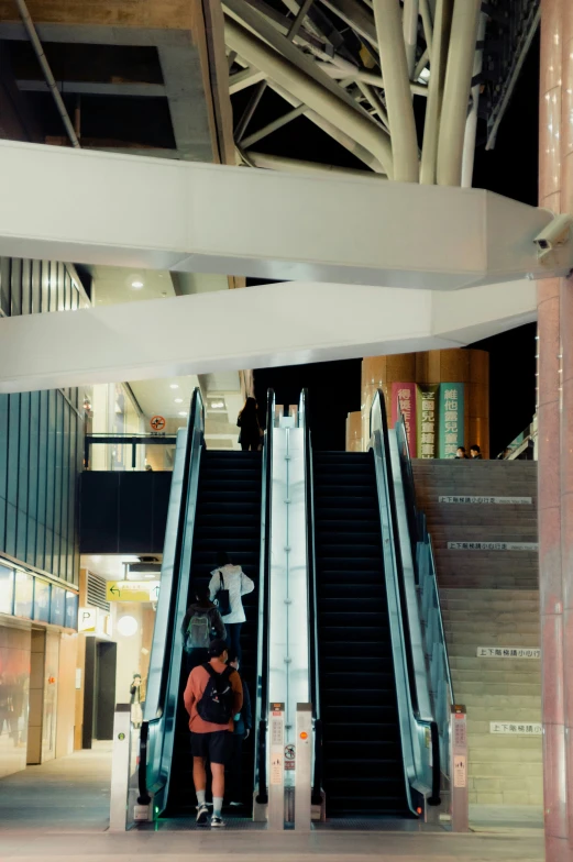 an escalator in a large building with people on the bottom