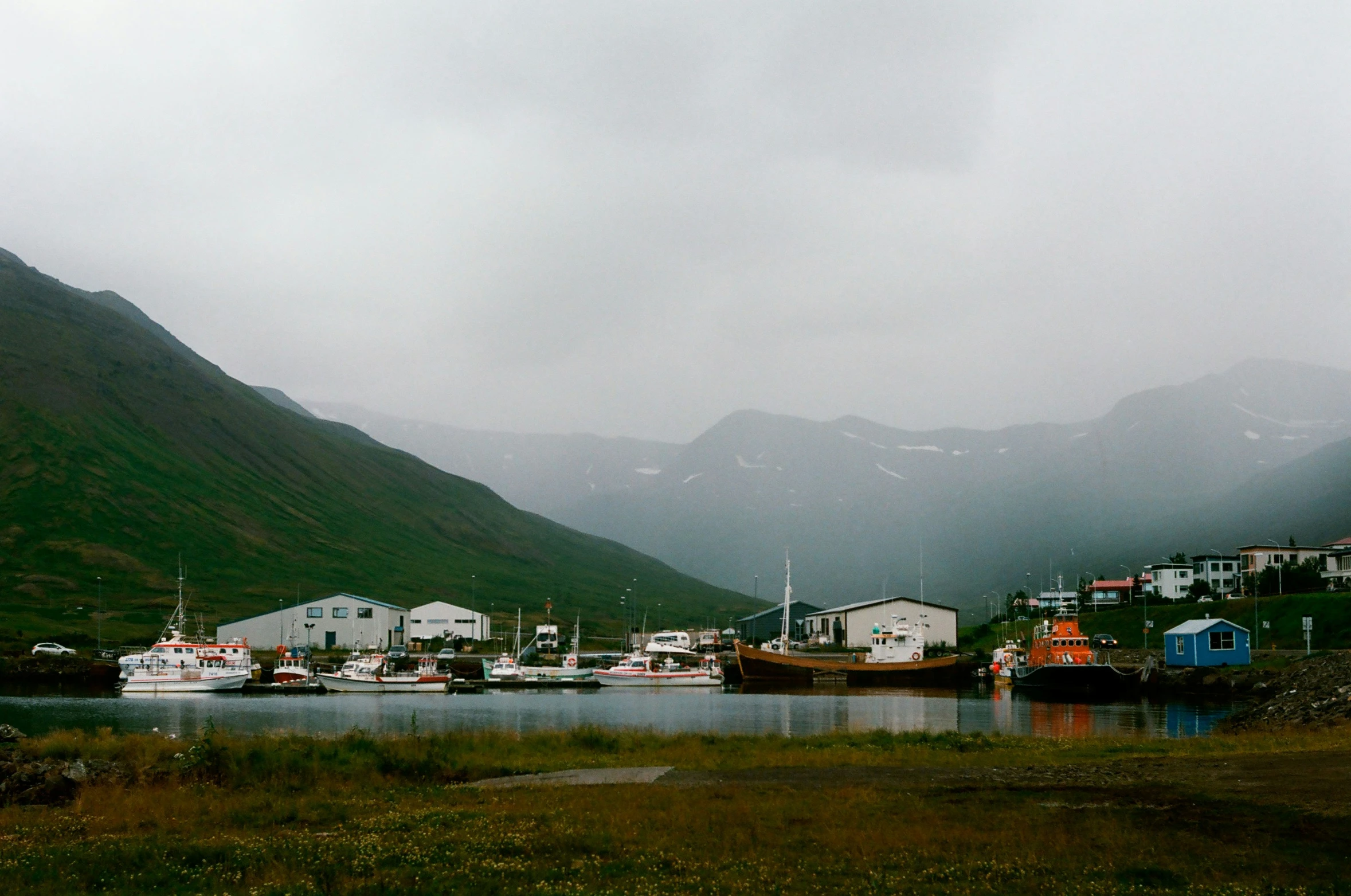 a boat is docked in a harbor by the mountains