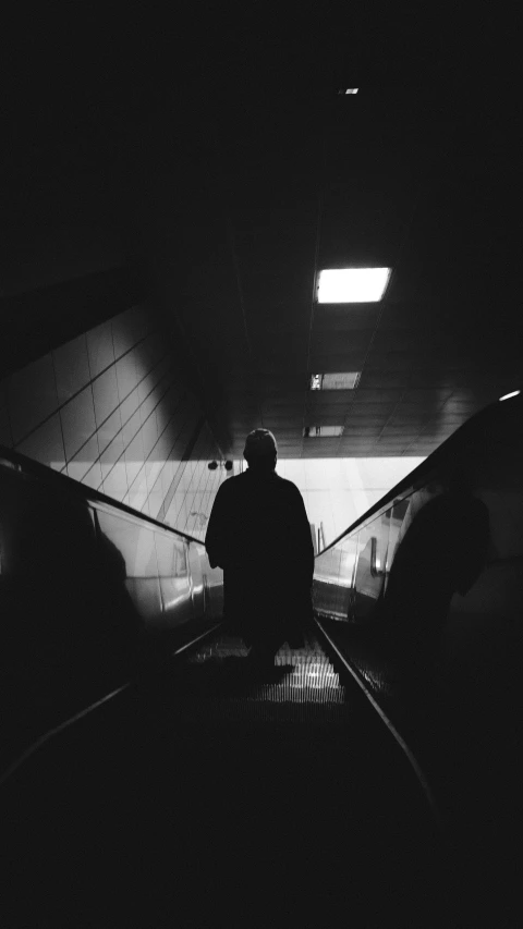 a man on top of an escalator in a building