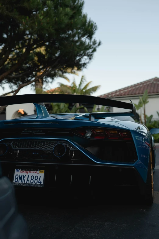 a blue sports car is parked next to a house