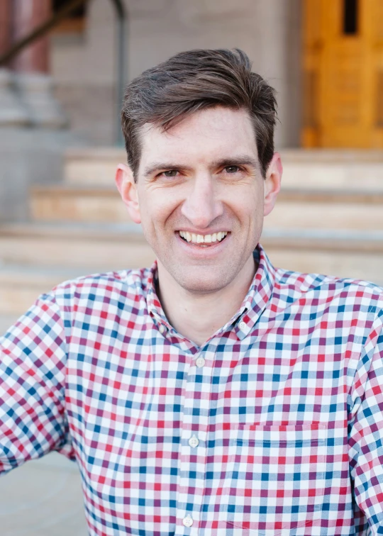 a close up of a person wearing a checkered shirt