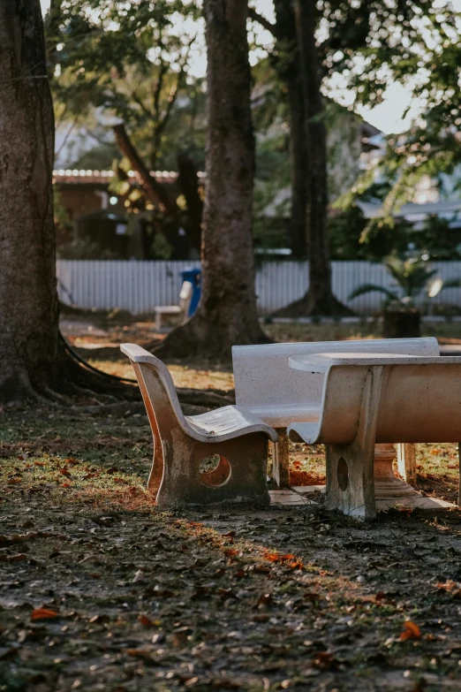 two empty white park benches in a park