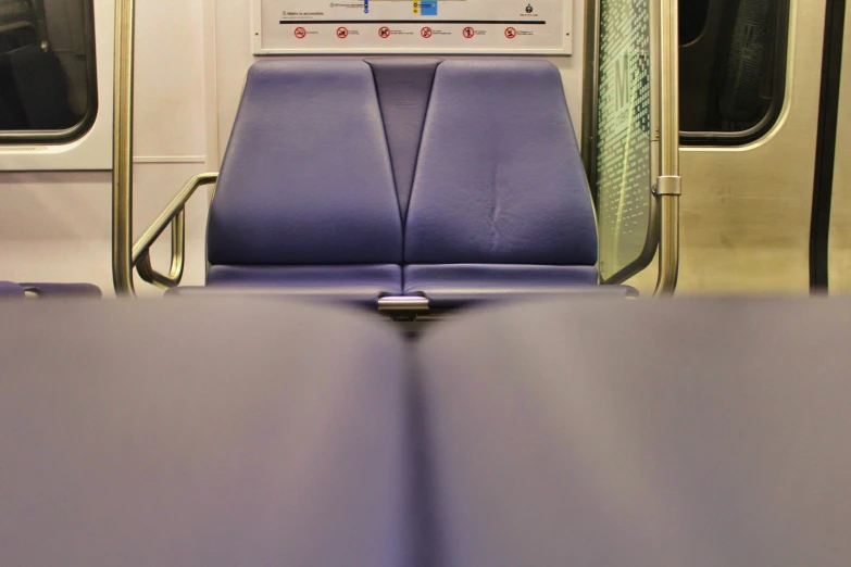 a purple seat sits next to a sliding door on a subway