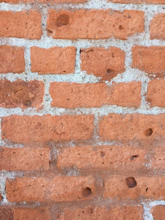 a close up po of a brick wall with small holes in it