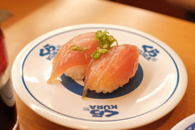 two sushi with green garnish served on white plates