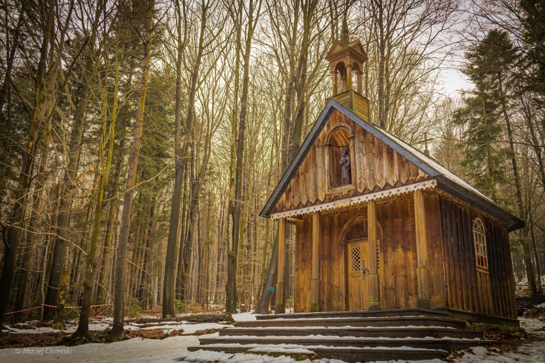 an old wooden church with steeple, stairs and windows