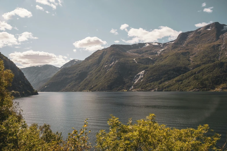 the mountains are in view over the water