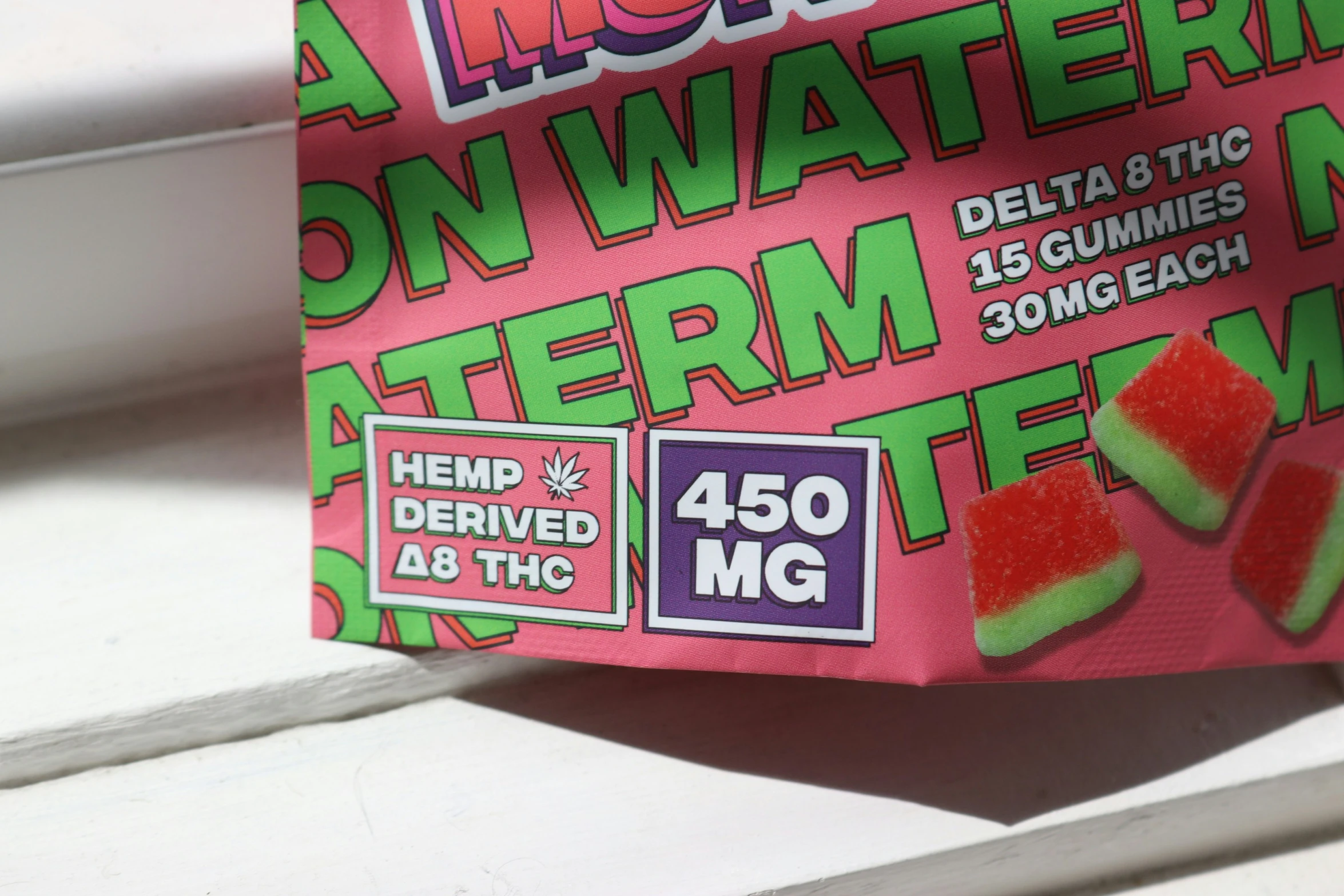 a bag of watermelon gummies hanging from a window sill