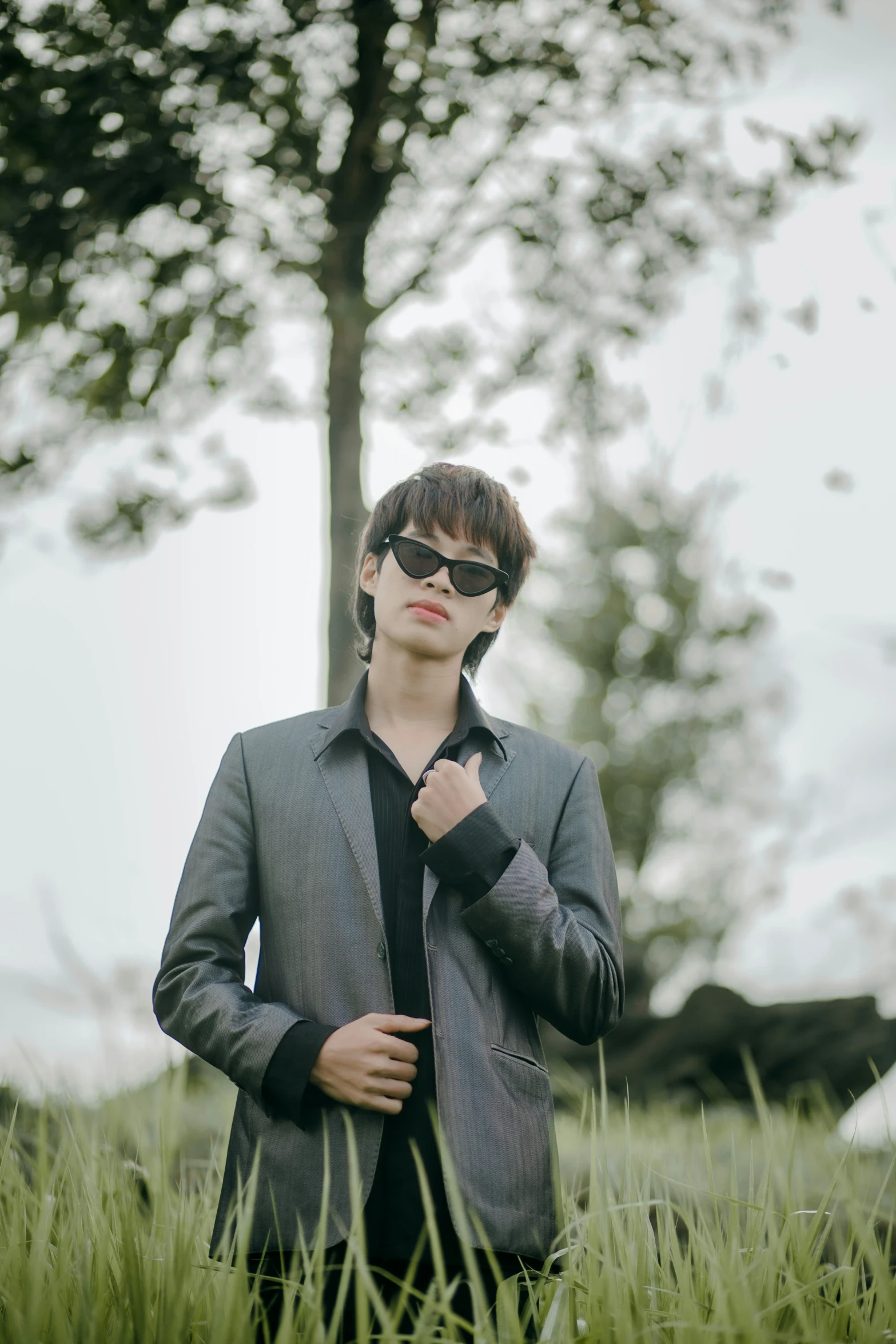 a man in a suit is standing by some grass