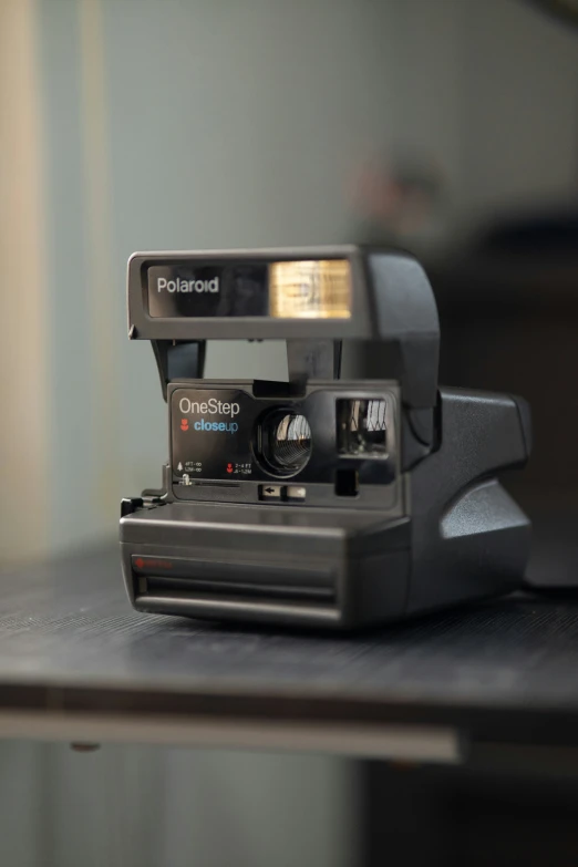 an old polaroid camera is sitting on a desk