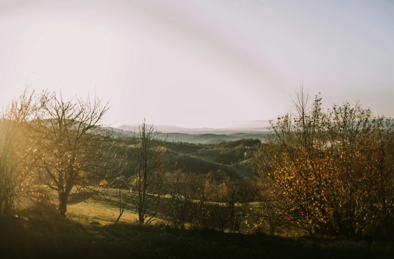 a view of the countryside with trees and hills