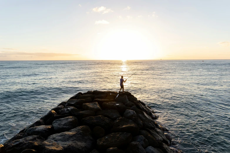 a man standing on the edge of a pier by the ocean