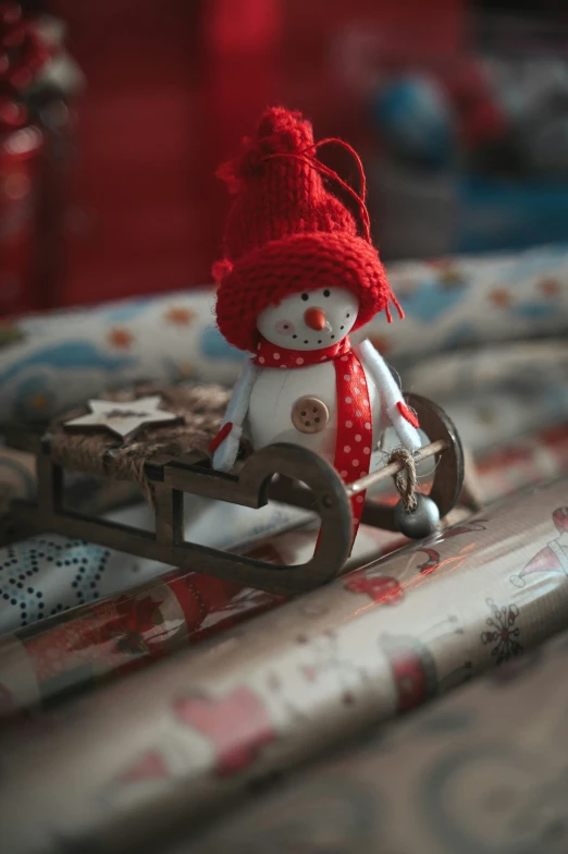 a tiny snowman toy sitting on top of a table