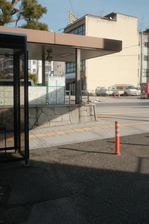 the bus stop is empty with two orange cones