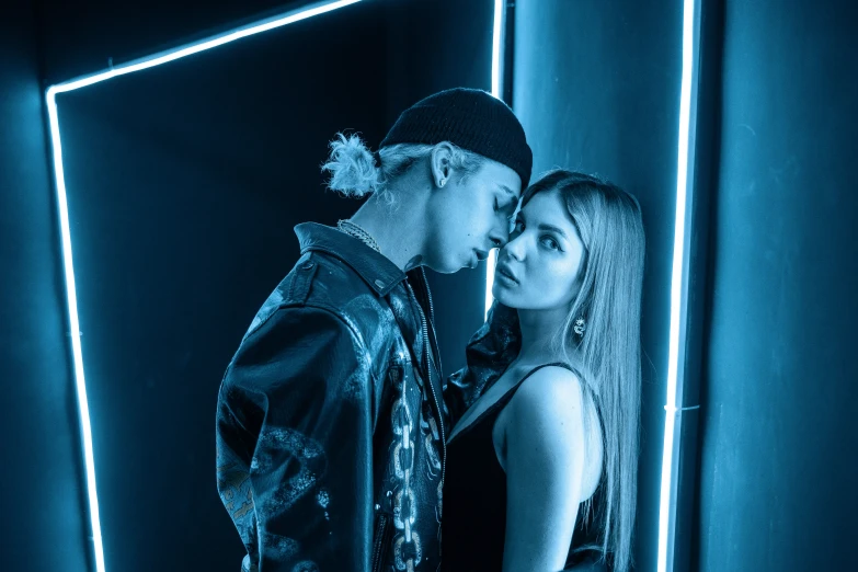 a young couple standing in front of a blue background