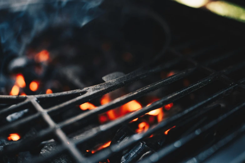 several flames burn in an outdoor grill