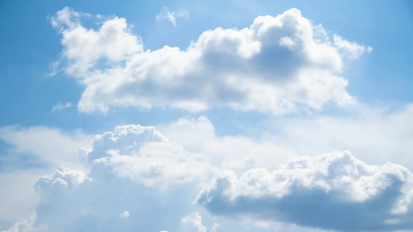 the sky has clouds all around and birds on the field