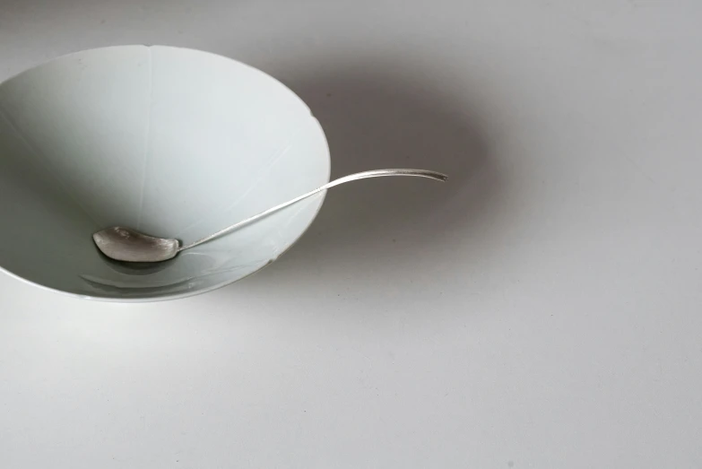 a white bowl with a spoon in it