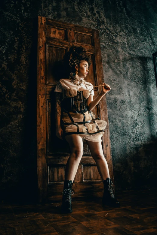 the woman is sitting on a wooden chair in a corset