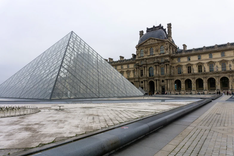 people walking in front of an old building and a pyramid