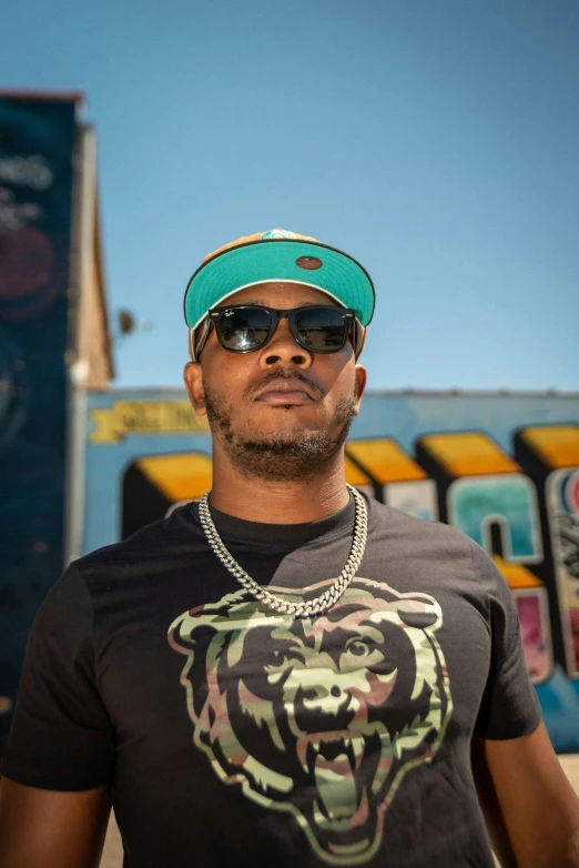 a man in shades and cap posing for a picture