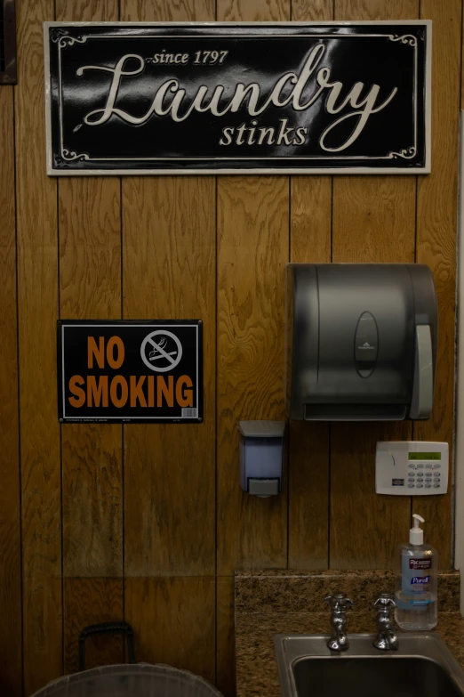 an old fashioned laundry stink dispenser next to a wall sign
