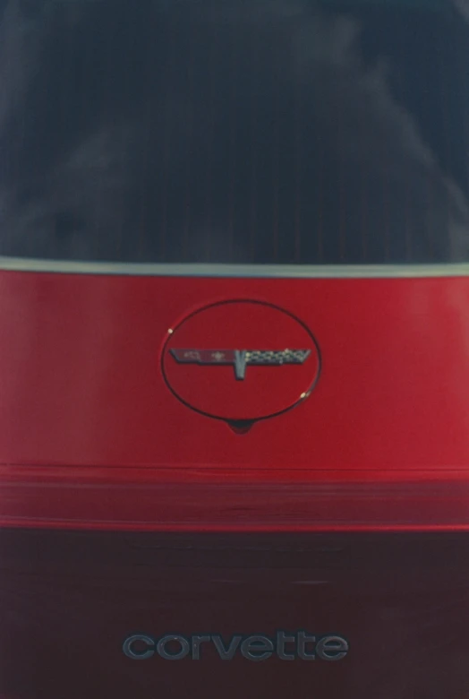a red car with corvette lettering and the logo on it