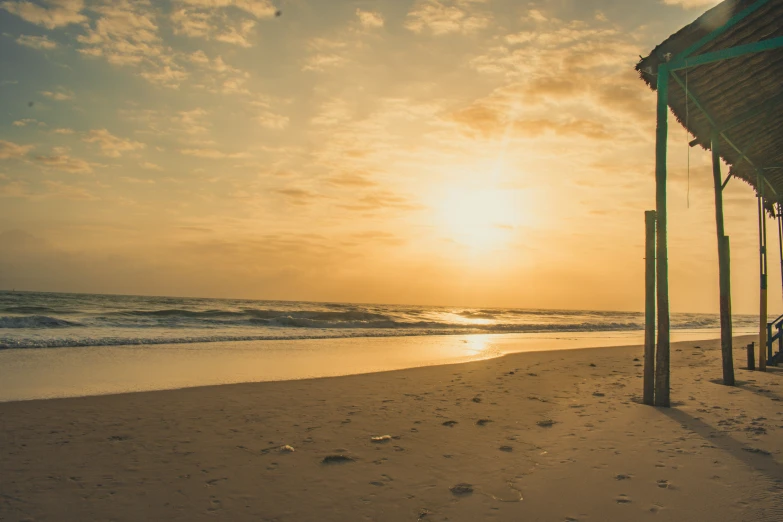 a view from the beach at sunset with footprints on the sand and on the water