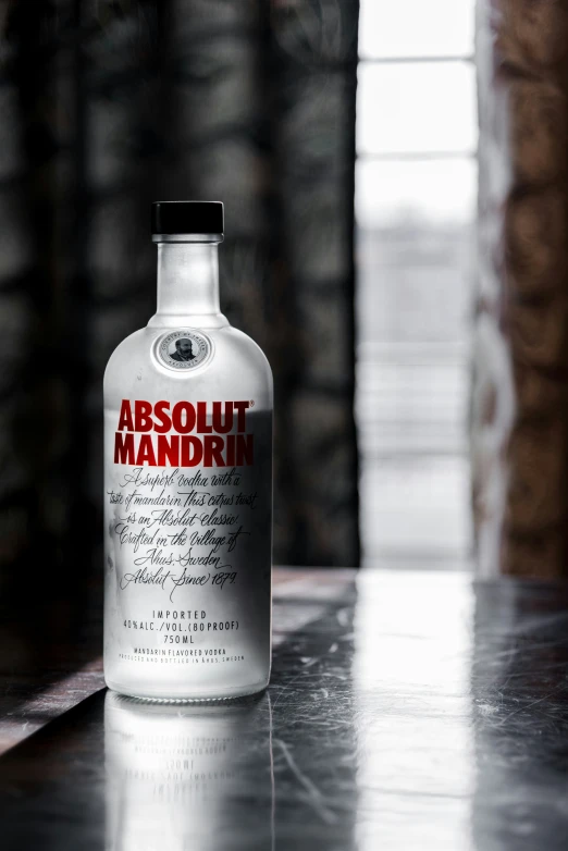 an absolut mandarin alcohol bottle is sitting on the table