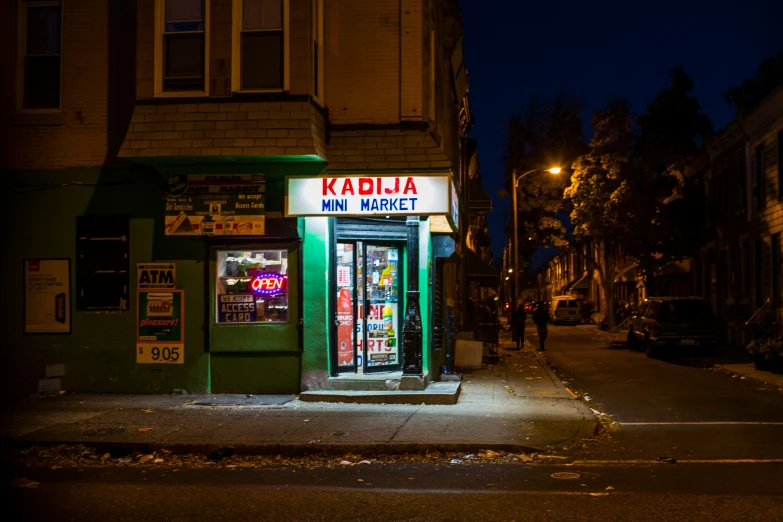 an old building with a neon sign and a neon kiosk