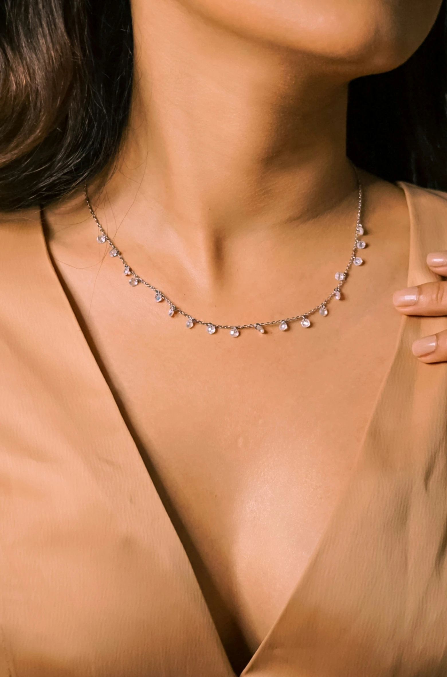 a close - up view of a woman's chest showing the necklace made from an 18ct gold diamond