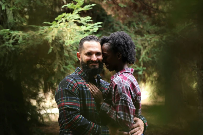 two men are hugging each other outside in the woods