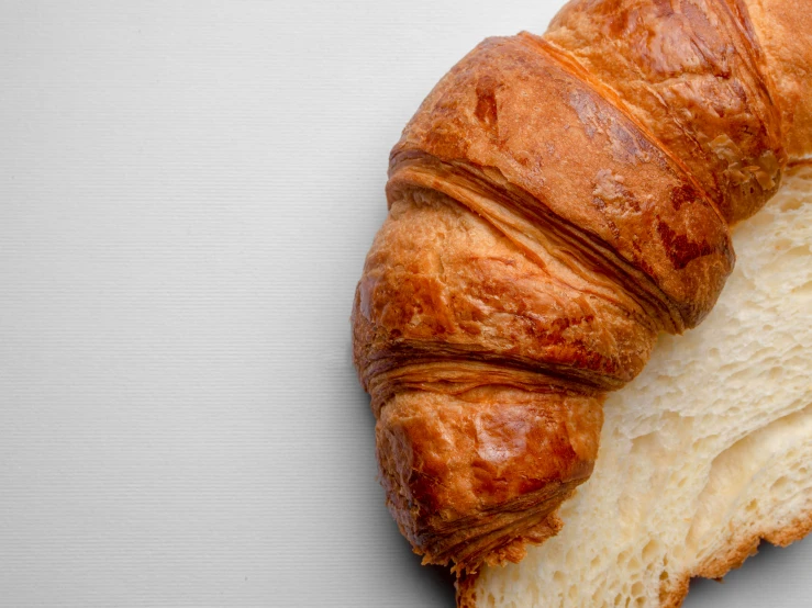 there is a croissant with a crocked end on a white surface