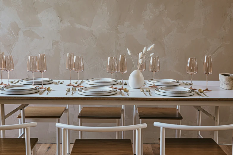 dining room table set up with plates and wine glasses