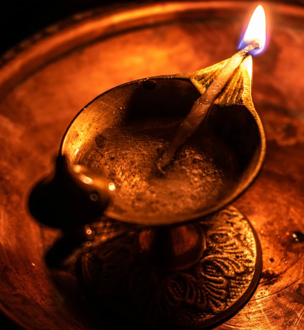 a tealight burning on top of an antique spoon